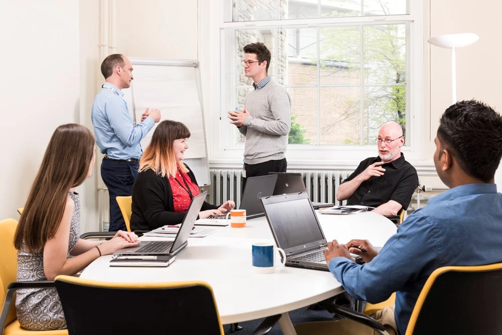 Developing an Inclusion, Diversity and Equality Strategy People around a table in an office meeting room