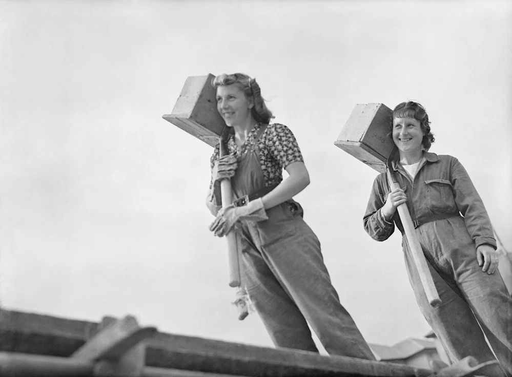 Women's History Black and white image of 2 women carrying bricks